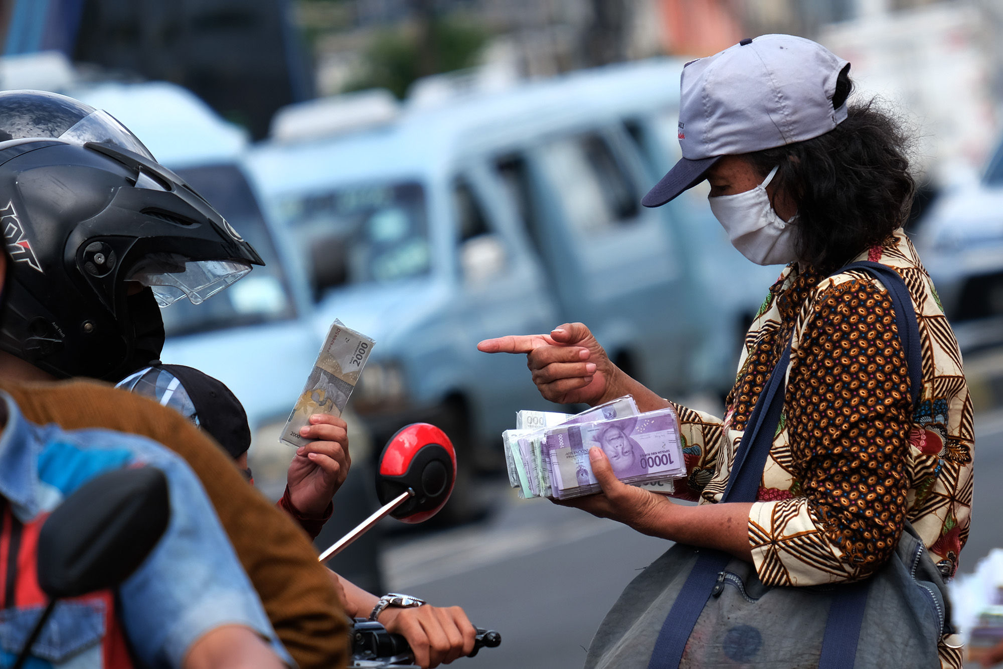 <p>Penjual jasa penukaran uang melayani konsumen di kawasan Kota Tua, Jakarta Barat, Sabtu 23 Mei 2020. Memasuki H-1 lebaran, warga masih banyak menggunakan jasa penukaran uang di pinggir jalan tersebut guna mendapatkan uang kertas baru pecahan Rp1.000 hingga Rp20.000, dengan biaya jasa sebesar Rp5000. Foto: Ismail Pohan/TrenAsia</p>
