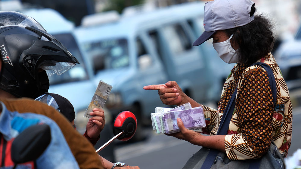 <p>Penjual jasa penukaran uang melayani konsumen di kawasan Kota Tua, Jakarta Barat, Sabtu 23 Mei 2020. Memasuki H-1 lebaran, warga masih banyak menggunakan jasa penukaran uang di pinggir jalan tersebut guna mendapatkan uang kertas baru pecahan Rp1.000 hingga Rp20.000, dengan biaya jasa sebesar Rp5000. Foto: Ismail Pohan/TrenAsia</p>
