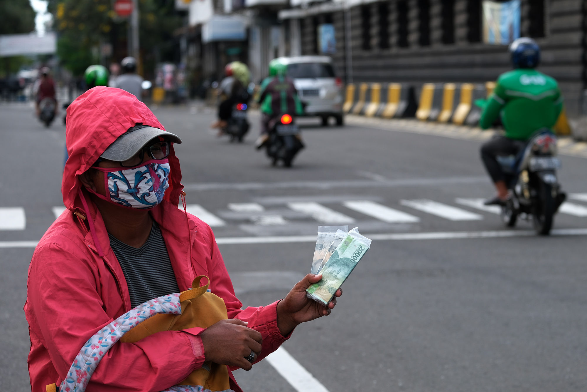 <p>Penjual jasa penukaran uang menunggu konsumen di kawasan Kota Tua, Jakarta Barat, Sabtu 23 Mei 2020. Memasuki H-1 lebaran, warga masih banyak menggunakan jasa penukaran uang di pinggir jalan tersebut guna mendapatkan uang kertas baru pecahan Rp1.000 hingga Rp20.000, dengan biaya jasa sebesar Rp5000. Foto: Ismail Pohan/TrenAsia</p>
