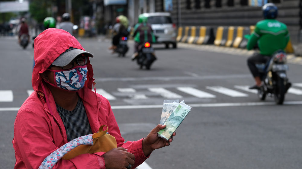 <p>Penjual jasa penukaran uang menunggu konsumen di kawasan Kota Tua, Jakarta Barat, Sabtu 23 Mei 2020. Memasuki H-1 lebaran, warga masih banyak menggunakan jasa penukaran uang di pinggir jalan tersebut guna mendapatkan uang kertas baru pecahan Rp1.000 hingga Rp20.000, dengan biaya jasa sebesar Rp5000. Foto: Ismail Pohan/TrenAsia</p>
