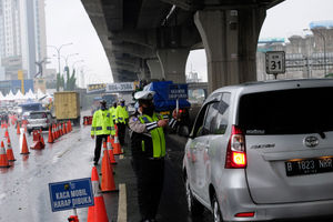 <p>Petuga kepolisian berjaga di pos penyekatan kendaraan melalui Tol Jakarta-Cikampek Km 31 di Cikarang Barat, Kabupaten Bekasi, Jawa Barat, Senin 18 Mei 2020. Memasuki H-6 Lebaran puluhan kendaraan masih terjaring razia penyekatan larangan mudik dan dipaksa putar balik keluar pintu tol kembali ke Jakarta. Walaupun larangan mudik diberlakukan sejak beberapa waktu lalu, sejumlah pemudik tetap nekat, mencoba mengelabui petugas, dan berharap lolos, dari pemeriksaan. Foto: Ismail Pohan/TrenAsia</p>
