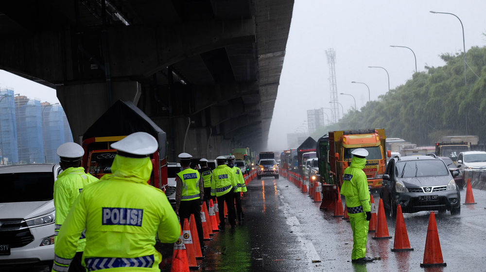 <p>Petuga kepolisian berjaga di pos penyekatan kendaraan melalui Tol Jakarta-Cikampek Km 31 di Cikarang Barat, Kabupaten Bekasi, Jawa Barat, Senin 18 Mei 2020. Memasuki H-6 Lebaran puluhan kendaraan masih terjaring razia penyekatan larangan mudik dan dipaksa putar balik keluar pintu tol kembali ke Jakarta. Walaupun larangan mudik diberlakukan sejak beberapa waktu lalu, sejumlah pemudik tetap nekat, mencoba mengelabui petugas, dan berharap lolos, dari pemeriksaan. Foto: Ismail Pohan/TrenAsia</p>
