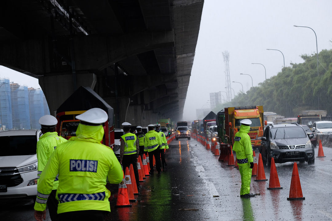 <p>Petuga kepolisian berjaga di pos penyekatan kendaraan melalui Tol Jakarta-Cikampek Km 31 di Cikarang Barat, Kabupaten Bekasi, Jawa Barat, Senin 18 Mei 2020. Memasuki H-6 Lebaran puluhan kendaraan masih terjaring razia penyekatan larangan mudik dan dipaksa putar balik keluar pintu tol kembali ke Jakarta. Walaupun larangan mudik diberlakukan sejak beberapa waktu lalu, sejumlah pemudik tetap nekat, mencoba mengelabui petugas, dan berharap lolos, dari pemeriksaan. Foto: Ismail Pohan/TrenAsia</p>
