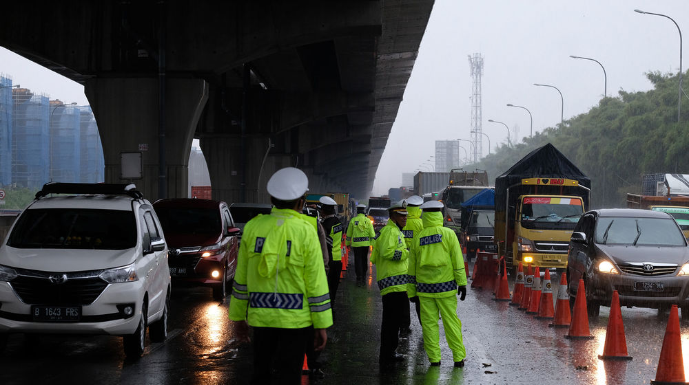 <p>Petuga kepolisian berjaga di pos penyekatan kendaraan melalui Tol Jakarta-Cikampek Km 31 di Cikarang Barat, Kabupaten Bekasi, Jawa Barat, Senin 18 Mei 2020. Memasuki H-6 Lebaran puluhan kendaraan masih terjaring razia penyekatan larangan mudik dan dipaksa putar balik keluar pintu tol kembali ke Jakarta. Walaupun larangan mudik diberlakukan sejak beberapa waktu lalu, sejumlah pemudik tetap nekat, mencoba mengelabui petugas, dan berharap lolos, dari pemeriksaan. Foto: Ismail Pohan/TrenAsia</p>
