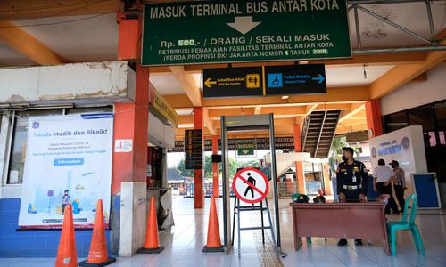 <p>Petugas berjaga di peron masuk Terminal Kampung Rambutan, Jakarta Timur, Sabtu 23 Mei 2020.  Sesuai dengan arahan pemerintah terkait pengendalian transportasi selama masa mudik lebaran,  sehingga terminal ditutup sejak 24 April dan akan dibuka kembali pada 31 Mei mendatang. Foto: Ismail Pohan/TrenAsia</p>
