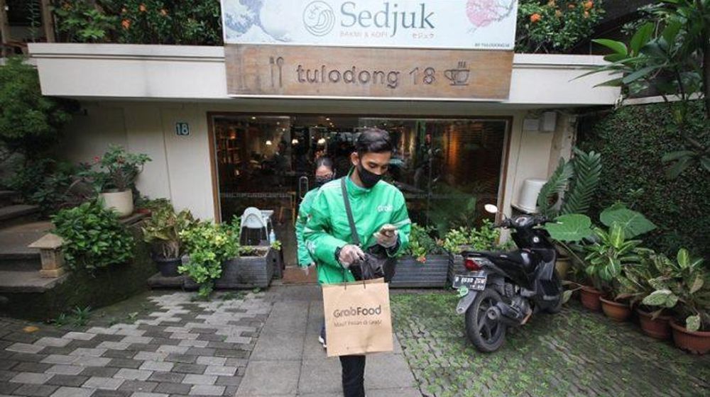 Pengemudi GrabFood melayani pemesanan makanan di salah satu Restoran Pilihan GrabFood.