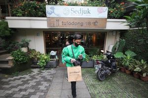 Pengemudi GrabFood melayani pemesanan makanan di salah satu Restoran Pilihan GrabFood.