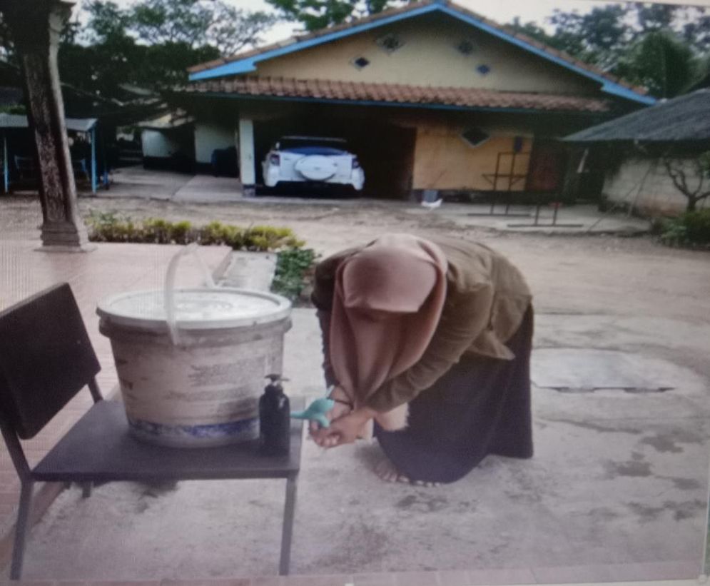 Mencuci tangan di depan rumah