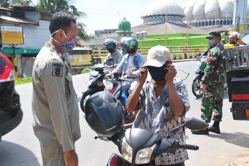 Petugas sedang melakukan patroli kedisiplinan masyarakat dalam menjalankan protokol kesehatan