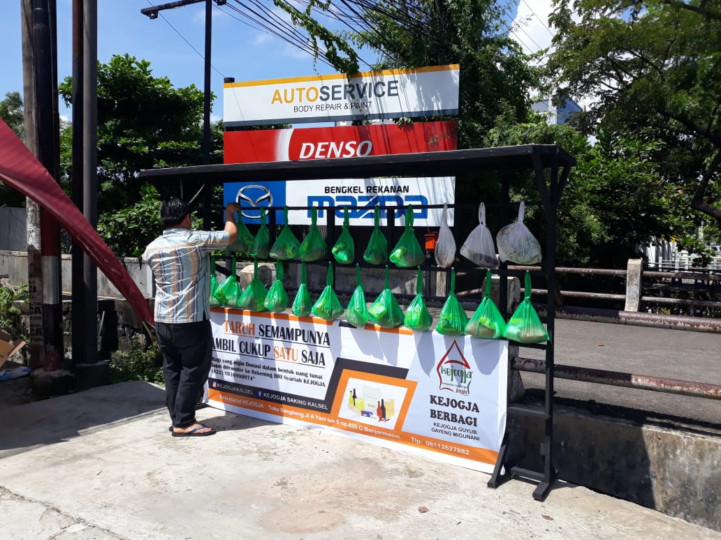 Salah satu warga mengambil sembako gratis yang disumbangkan masyarakat