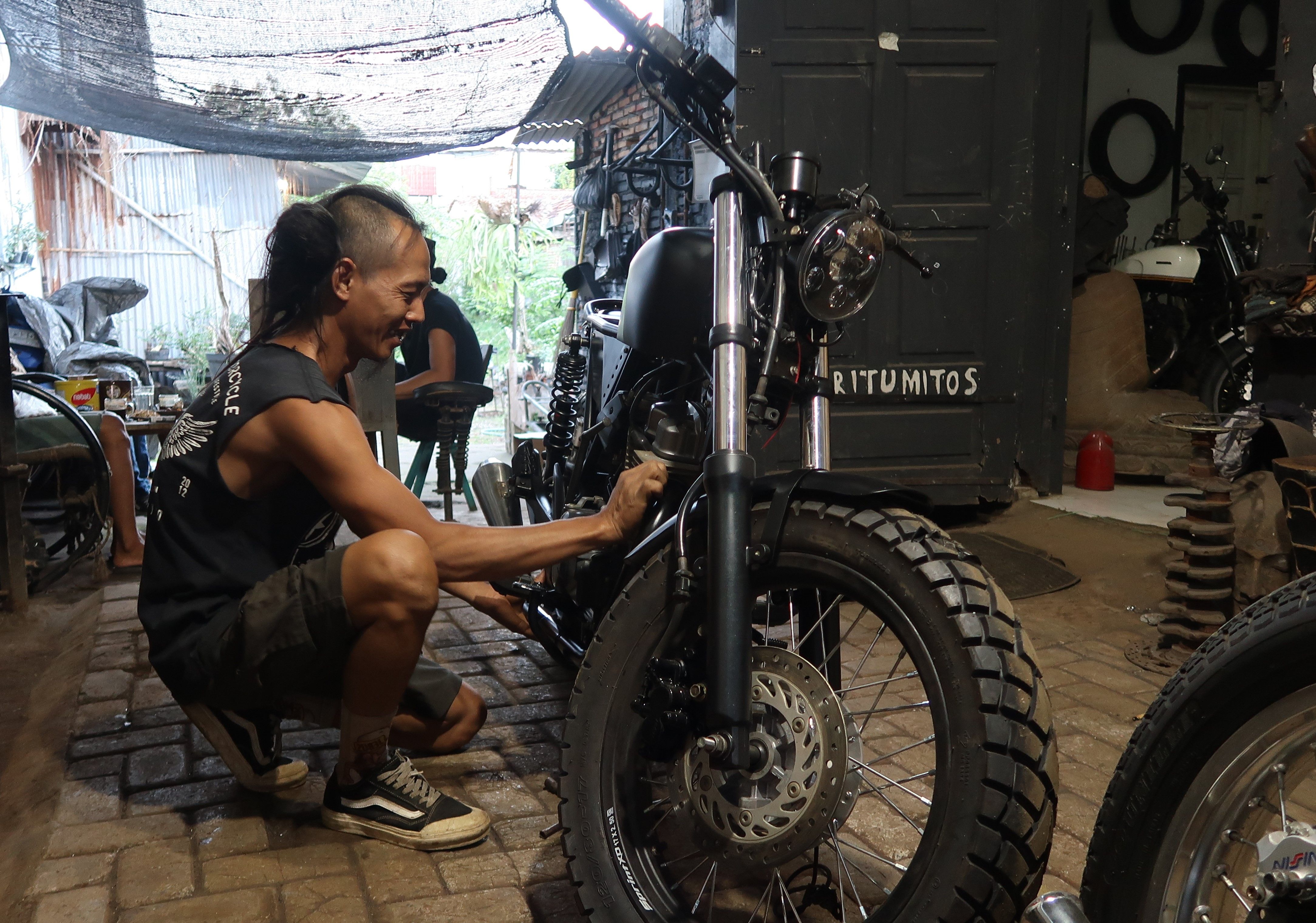 Bowo sedang membuat motor custom.
