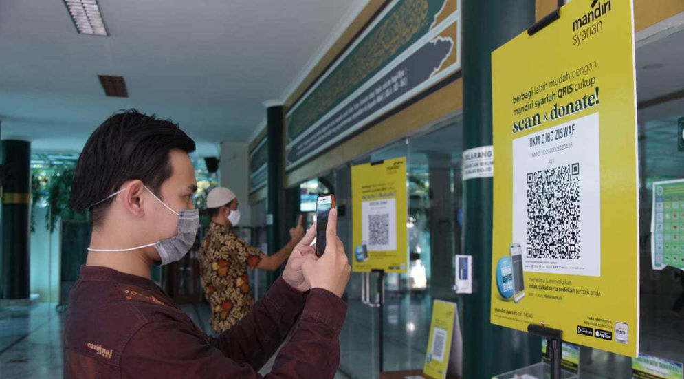 Seorang nasabah Bank Syariah Mandiri tengah melakukan scan QRIS. Foto ist