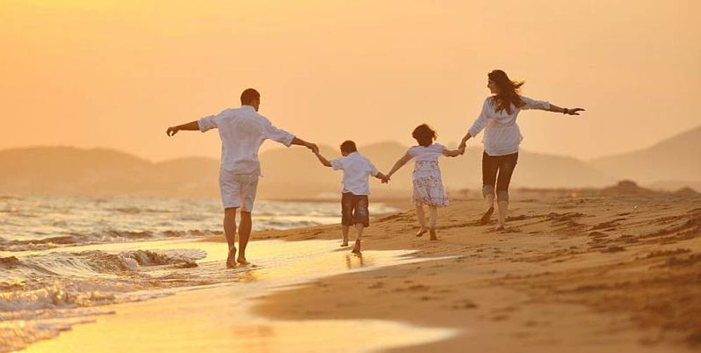 Ilustrasi keluarga yang tengah bermain di pantai