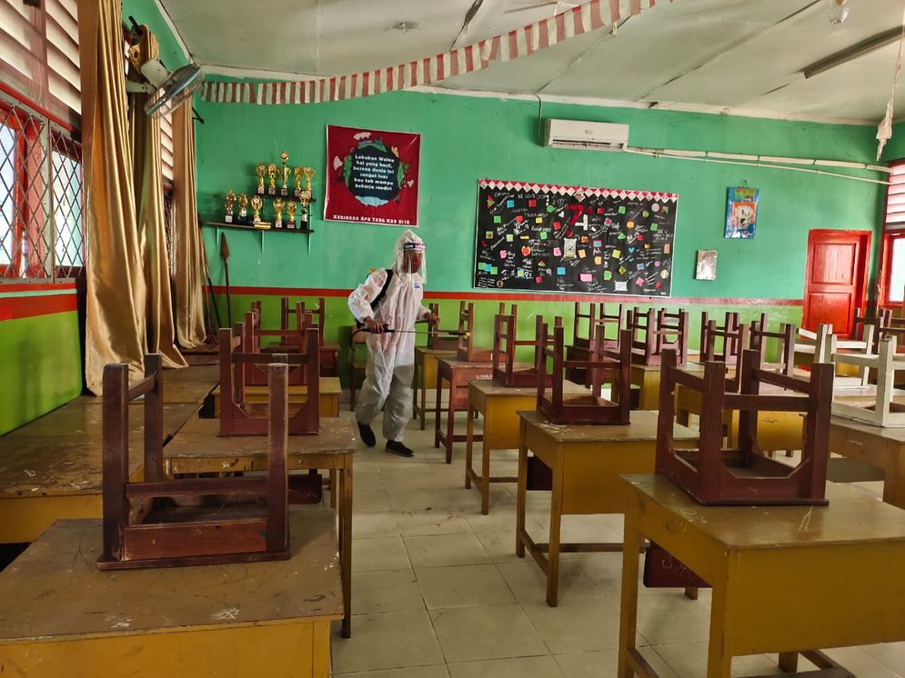 etugas saat melakukan penyemprotan disinfektan di SMA Negeri 15 Palembang untuk pencegahan pandemi COVID-19