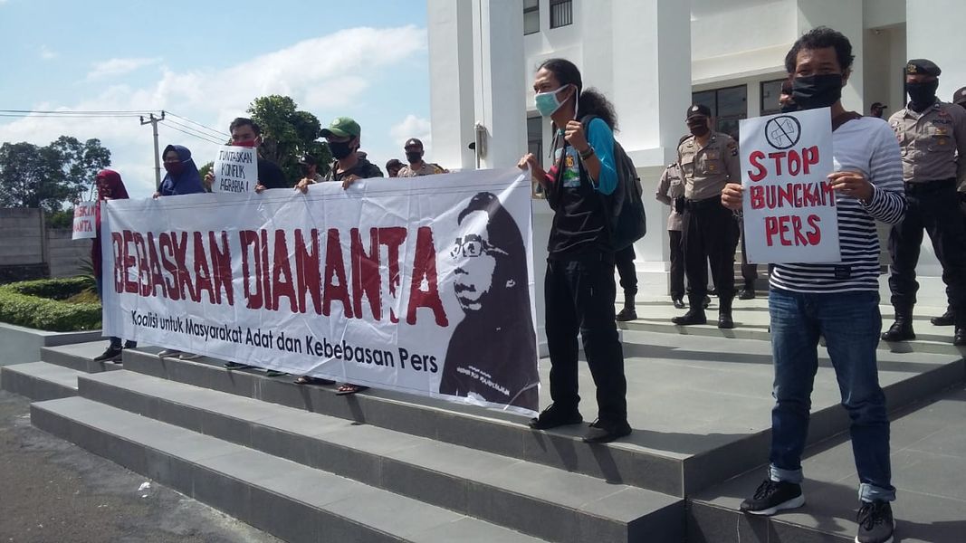 massa dari Koalisi untuk masyarakat adat dan kebebasan pers membentang spanduk ukuran 1x5 meter di depan gedung PT Banjarmasin