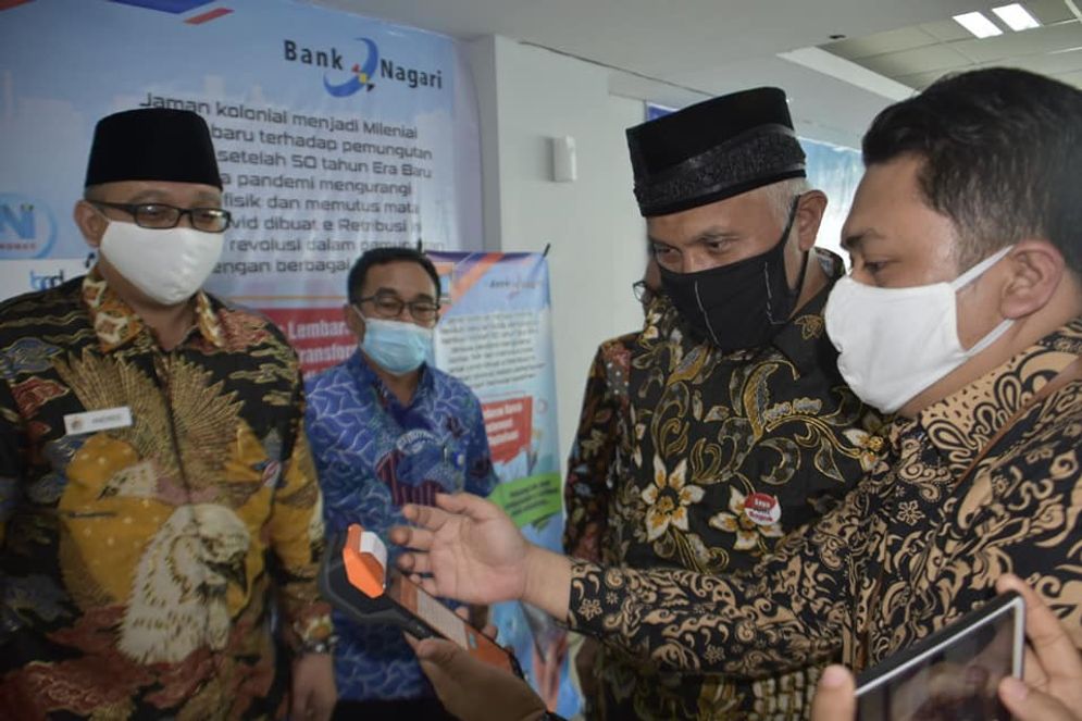 Wali Kota Padang Mahyeldi (tengah kanan) bersama Direktur Keuangan Bank Nagari M Irsyad saat melakukan demo penggunakan e-Retribusi. Foto: Ist