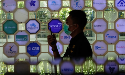 <p>Petugas keamanan berjaga dengan latar belakang logo beberapa perusahaan asuransi di Kantor Asosiasi Asuransi Jiwa Indonesia (AAJI) di Jakarta, Rabu 10 Juni 2020. Berdasarkan data Otoritas Jasa Keuangan (OJK) pada Maret 2020 nilai aset asuransi jiwa mengalami penurunan secara tahun berjalan maupun secara tahunan sedangkan asuransi umum justru tumbuh, industri asuransi jiwa mencatatkan total aset Rp 529,2 trilun atau menurun 10,4 % (ytd) dari Desember 2019 senilai Rp 590,7 triliun. Foto: Ismail Pohan/TrenAsia</p>
