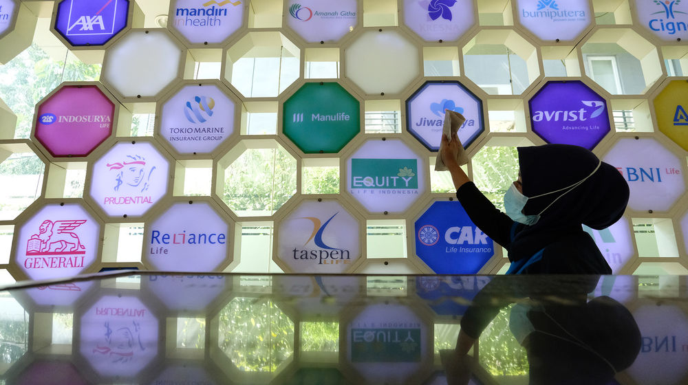 <p>Pekerja membersihkan logo beberapa perusahaan asuransi di Kantor Asosiasi Asuransi Jiwa Indonesia (AAJI) di Jakarta, Rabu 10 Juni 2020. Berdasarkan data Otoritas Jasa Keuangan (OJK) pada Maret 2020 nilai aset asuransi jiwa mengalami penurunan secara tahun berjalan maupun secara tahunan sedangkan asuransi umum justru tumbuh, industri asuransi jiwa mencatatkan total aset Rp 529,2 trilun atau menurun 10,4 % (ytd) dari Desember 2019 senilai Rp 590,7 triliun. Foto: Ismail Pohan/TrenAsia</p>
