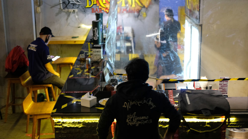 <p>Pengunjung berada di area bar dengan pembatas jarak di salah satu tempat hiburan malam di kawasan Kemang, Jakarta, Senin 22 Juni 2020. Memasuki masa pembatasan sosial berskala besar (PSBB) transisi sejumlah tempat hiburan malam kembali dibuka dengan aturan baru new normal memperketat protokol kesehatan pencegahan penyebaran virus corona. Penerapan protokol baru diharapkan mampu menarik kembali pelanggan serta membangunkan sektor bisnis hiburan malam yang hampir tenggelam ditengah pandemi Covid-19 saat ini. Foto: Ismail Pohan/TrenAsia</p>
