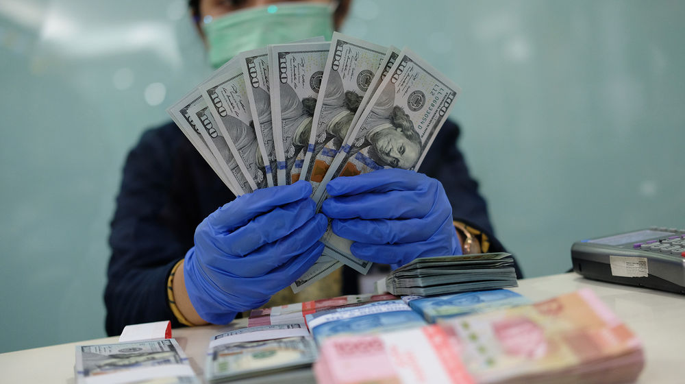 <p>Karyawan menunjukkan uang Dolar Amerika Serikat (AS) di salah satu Bank BUMN di Jakarta, Selasa 2 Juni 2020. Nilai tukar rupiah terhadap dolar Amerika Serikat (AS) menguat cukup signifikan pada penutupan perdagangan hari ini, nilai tukar rupiah di pasar spot ditutup menguat 195 poin atau 1,33 persen ke level Rp14.415 per dolar AS. Sementara itu, indeks dolar AS terpantau menguat 0,039 poin atau 0,04 persen ke level 97,869 pada pukul 14.53 WIB. New Normal yang akan diberlakukan secara bertahap dianggap menjadi sentimen positif terhadap pergerakan pasar saat ini. Foto: Ismail Pohan/TrenAsia</p>
