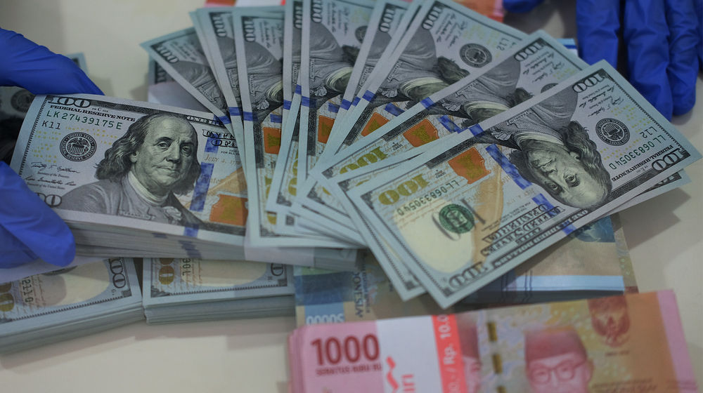 <p>Karyawan menunjukkan uang Dolar Amerika Serikat (AS) di salah satu Bank BUMN di Jakarta, Selasa 2 Juni 2020. Foto: Ismail Pohan/TreAsia</p>
