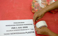 <p>Pedagang memasang pengumuman larangan penggunaan kantong plastik dikiosnya Pasar Mitra Tani Ragunan, Jakarta, Selasa 30 Juni 2020. Pasar ini akan melarang penggunaan kantong plastik sekali pakai untuk seluruh tenant dan konsumen pasar sejak Rabu 1 Juli 2020. Hal ini sesuai Peraturan Gubernur  DKI Jakarta No. 142 Tahun 2019 tentang Kewajiban Penggunaan Kantong Belanja Ramah Lingkungan Pada Pusat Perbelanjaan, Toko Swalayan dan Pasar Rakyat di Jakarta. Foto: Ismail Pohan/TrenAsia</p>
