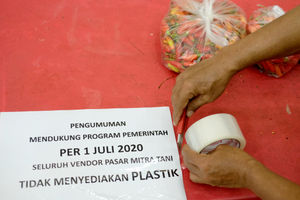 <p>Pedagang memasang pengumuman larangan penggunaan kantong plastik dikiosnya Pasar Mitra Tani Ragunan, Jakarta, Selasa 30 Juni 2020. Pasar ini akan melarang penggunaan kantong plastik sekali pakai untuk seluruh tenant dan konsumen pasar sejak Rabu 1 Juli 2020. Hal ini sesuai Peraturan Gubernur DKI Jakarta No. 142 Tahun 2019 tentang Kewajiban Penggunaan Kantong Belanja Ramah Lingkungan Pada Pusat Perbelanjaan, Toko Swalayan dan Pasar Rakyat di Jakarta. Foto: Ismail Pohan/TrenAsia</p>