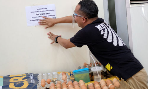 <p>Pedagang memasang pengumuman larangan penggunaan kantong plastik dikiosnya Pasar Mitra Tani Ragunan, Jakarta, Selasa 30 Juni 2020. Pasar ini akan melarang penggunaan kantong plastik sekali pakai untuk seluruh tenant dan konsumen pasar sejak Rabu 1 Juli 2020. Hal ini sesuai Peraturan Gubernur  DKI Jakarta No. 142 Tahun 2019 tentang Kewajiban Penggunaan Kantong Belanja Ramah Lingkungan Pada Pusat Perbelanjaan, Toko Swalayan dan Pasar Rakyat di Jakarta. Foto: Ismail Pohan/TrenAsia</p>
