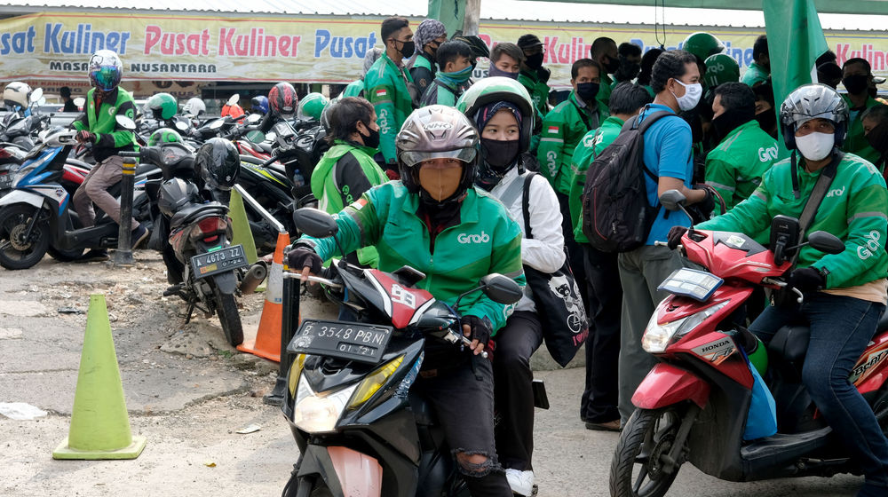 <p>Ojek online mangambil penumpang di kawasan stasiun Sudirman, Jakarta, Senin 8 Juni 2020. Setelah Pemerintah Provinsi DKI Jakarta melonggarkan pembatasan sosial berskala besar (PSBB) dan memasuki fase transisi, mulai Senin 8 Juni 2020, layanan ojek online GoRide dan Grab Bike sudah bisa digunakan kembali oleh masyarakat. Foto: Ismail Pohan/TrenAsia</p>
