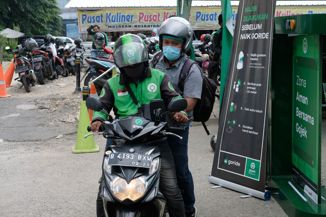 <p>Ojek online mangambil penumpang di kawasan stasiun Sudirman, Jakarta, Senin 8 Juni 2020. Setelah Pemerintah Provinsi DKI Jakarta melonggarkan pembatasan sosial berskala besar (PSBB) dan memasuki fase transisi, mulai Senin 8 Juni 2020, layanan ojek online GoRide dan Grab Bike sudah bisa digunakan kembali oleh masyarakat. Foto: Ismail Pohan/TrenAsia</p>
