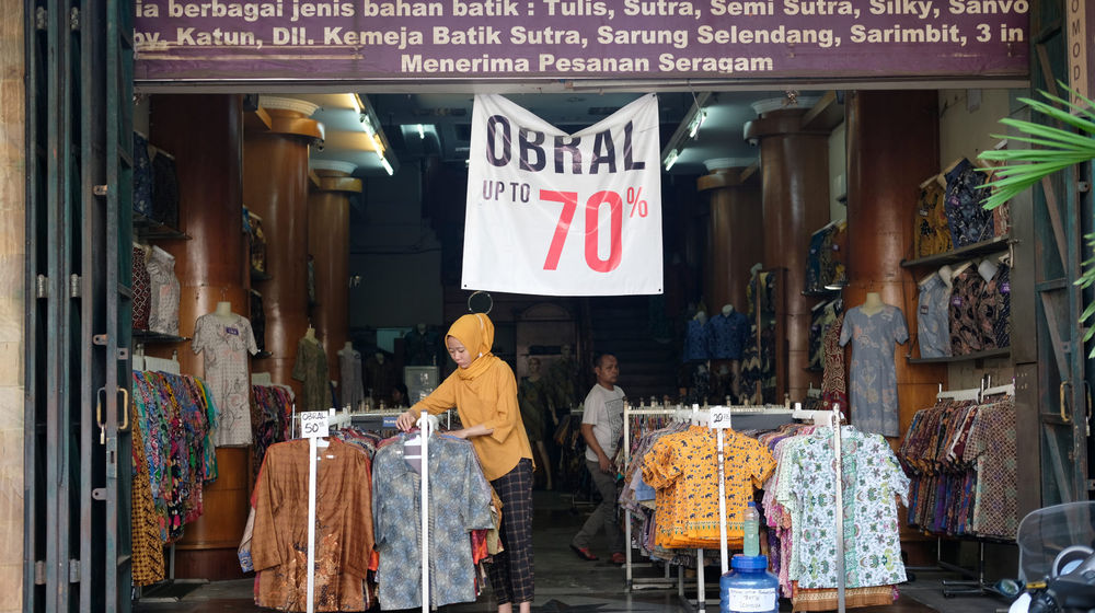 <p>Pekerja menata barang dagangan di salah satu toko kawasan Pasar Baru, Jakarta, Kamis 11 Juni 2020. Meski masih dalam masa Pembatasan Sosial Berskala Besar (PSBB) transisi, pusat perbelanjaan tersebut mulai dibuka kembali dengan memperhatikan protokol kesehatan pencegahan Covid-19 menuju pemberlakuan kenormalan baru. Foto: Ismail Pohan/TrenAsia</p>
