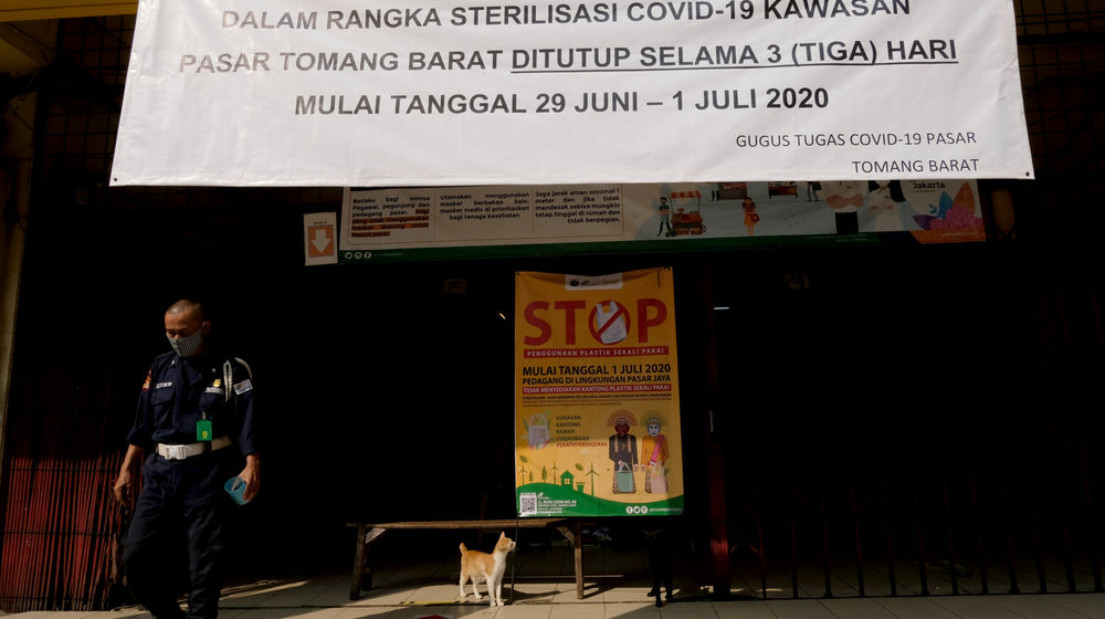 <p>Petugas keamanan berjaga di area Pasar Tomang Barat, Jakarta, Senin 29 Juni 2020. Pasar Tomang Barat atau yang lebih dikenal dengan sebutan Pasar Kopro ditutup setelah ada pedagang positif COVID-19 dari hasil tes usap. Rencananya pasar ini akan kembali dibuka pada Rabu 1 Juli 2020. Hingga kini, telah keluar hasil tes usap 135 pedagang. Foto: Ismail Pohan/TrenAsia</p>
