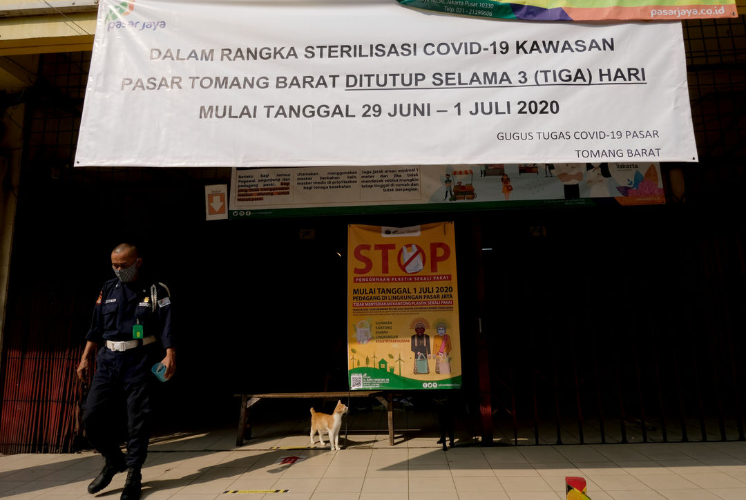 <p>Petugas keamanan berjaga di area Pasar Tomang Barat, Jakarta, Senin 29 Juni 2020. Pasar Tomang Barat atau yang lebih dikenal dengan sebutan Pasar Kopro ditutup setelah ada pedagang positif COVID-19 dari hasil tes usap. Rencananya pasar ini akan kembali dibuka pada Rabu 1 Juli 2020. Hingga kini, telah keluar hasil tes usap 135 pedagang. Foto: Ismail Pohan/TrenAsia</p>
