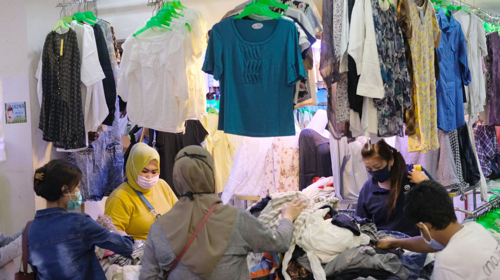 <p>Calon pembeli memilih pakaian di salah satu kios pedagang pakaian bekas atau import di Pasar Senen Blok III, Jakarta, Jum’at 12 Juni 2020. Pasar yang tetap buka selama pemberlakuan PSBB dengan pembatasan jam operasional dari pukul 10.00 – 14.00 setiap harinya ini akan dibuka normal kembali pada Senin 15 Juni 2020 mendatang dengan aturan protokol kesehatan Covid-19. Foto: Ismail Pohan/TrenAsia</p>
