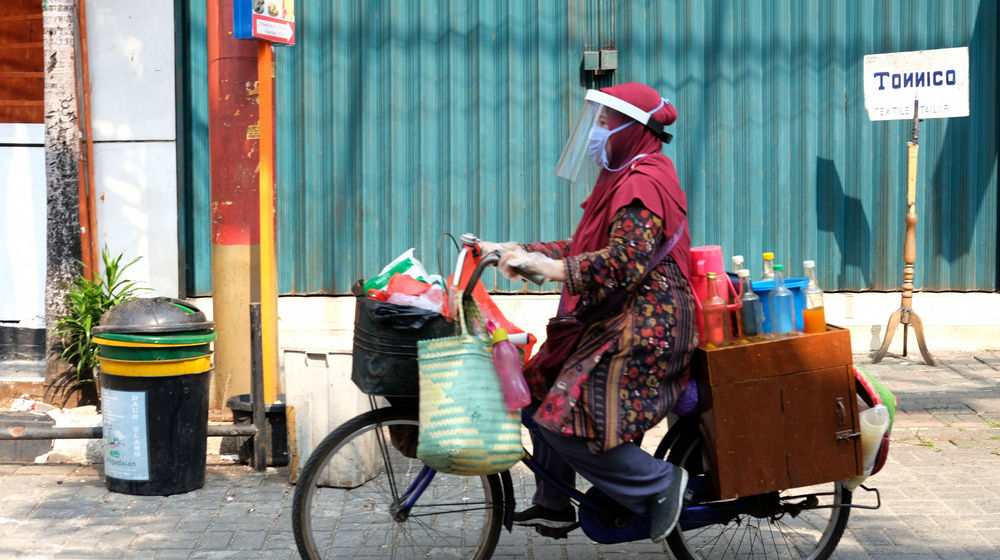 <p>Tidar (46), mengayuh sepeda nya berjualan jamu keliling di Pasar Baru, Jakarta Pusat, Kamis 11 Juni 2020. Penjual jamu tradisional keliling ini tampak mematuhi protokol kesehatan pencegahan COVID-19 dengan mengenakan masker, face shield, dan sarung tangan dalam melayani pelanggan setianya di masa PSBB transisi.  Foto: Ismail Pohan/TrenAsia</p>
