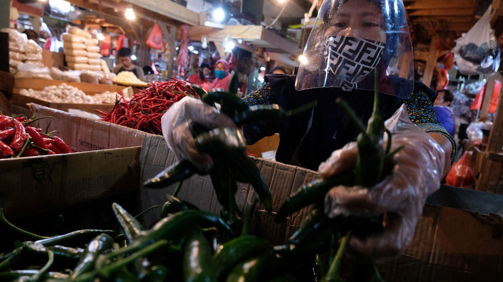 <p>Pedagang mengenakan face shield dan sarung tangan menata barang dagangannya di los sayuran Pasar Senen, Jakarta, 1 Juni 2020. Kementerian Perdagangan menyiapkan pedoman bagi penyelenggara kegiatan perdagangan untuk diterapkan pada saat kenormalan baru (new normal). Saat era new normal, para pedagang di pasar rakyat diwajibkan menggunakan masker, face shield, dan sarung tangan selama beraktivitas. Selain itu, kegiatan pasar juga hanya diperbolehkan pada pukul 06.00 hingga 11.00. Para pedagang yang diperbolehkan berjualan adalah mereka yang memiliki suhu tubuh di bawah 37,3 derajat celcius. Foto: Ismail Pohan/TrenAsia</p>
