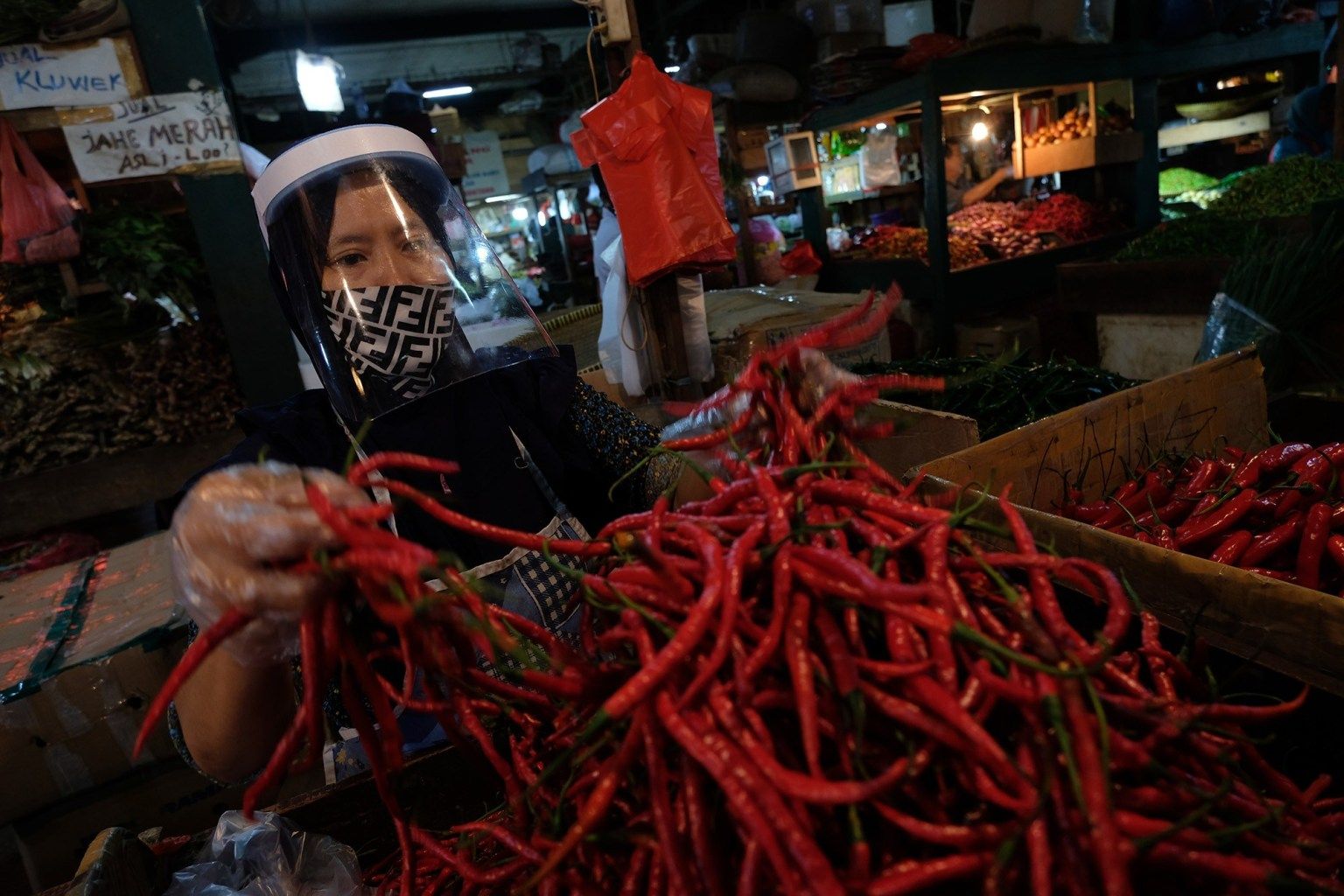 <p>Pedagang mengenakan face shield dan sarung tangan menata barang dagangannya di los sayuran Pasar Senen, Jakarta, 1 Juni 2020. Foto: Ismail Pohan/TrenAsia</p>
