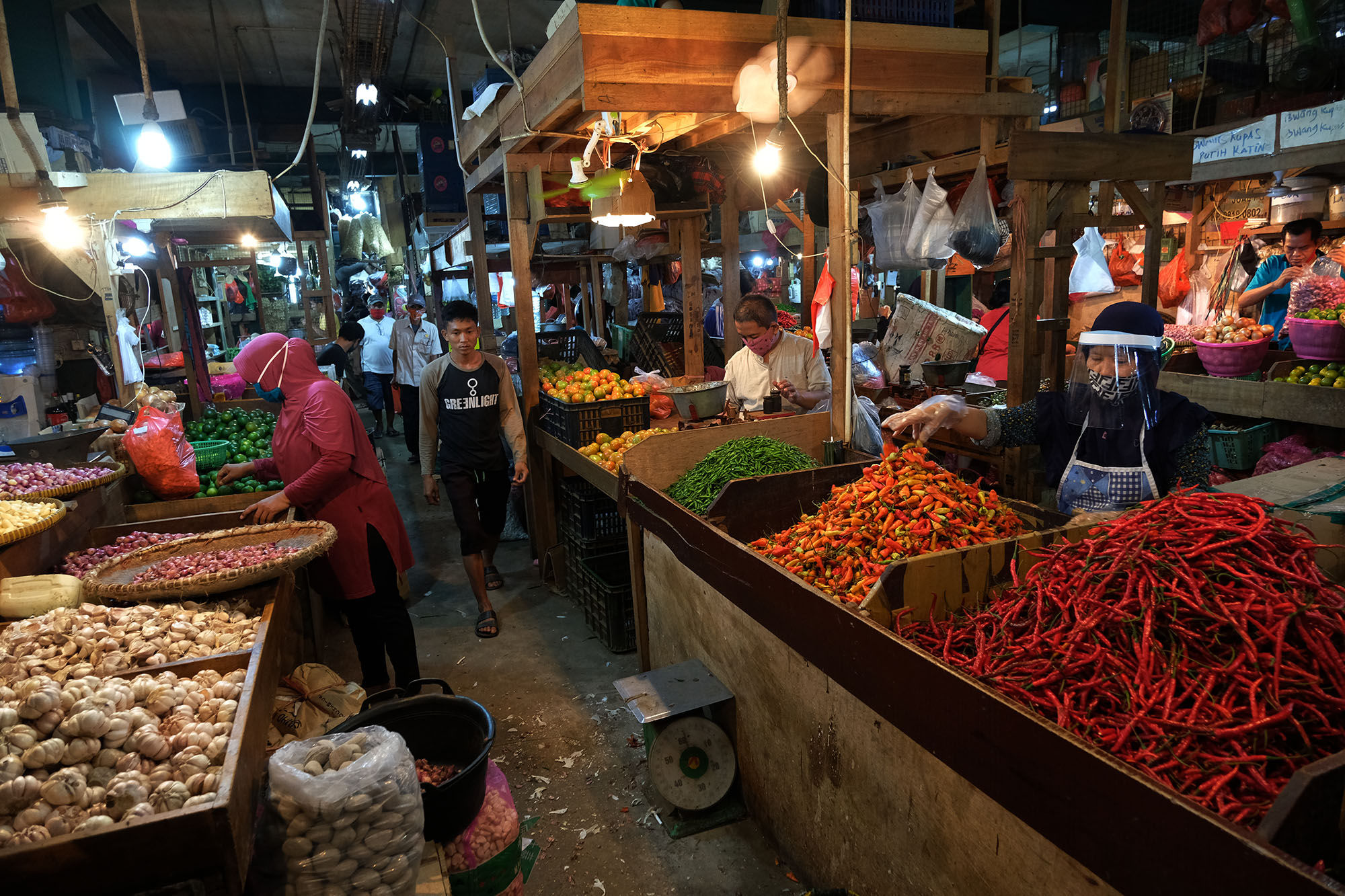 <p>Pedagang mengenakan face shield dan sarung tangan saat melayani pembeli di los sayuran Pasar Senen, Jakarta, 1 Juni 2020. Foto: Ismail Pohan/TrenAsia</p>
