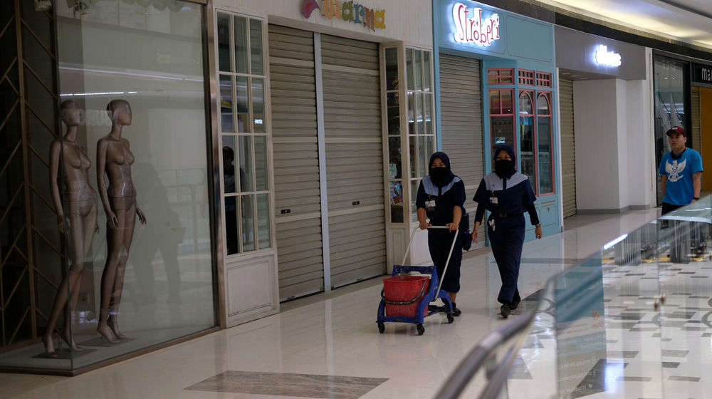 <p>Pekerja melintas di depan tenant yang masih tutup di area Lippo Mall Puri, Jakarta Barat, Rabu 3 Juni 2020. Lippo Mall Indonesia menyiapkan prosedur menuju new normal di  seluruh mall menyambut pembukaan kembali. Prosedur kebersihan dan keamanan pengunjung dan karyawan yang telah disiapkan mengacu pada protokol kesehatan guna mendukung Pemerintah dalam menerapkan new normal agar masyarakat tetap produktif, disiplin, serta waspada terhadap penyebaran Covid-19. Foto: Ismail Pohan/TrenAsia</p>
