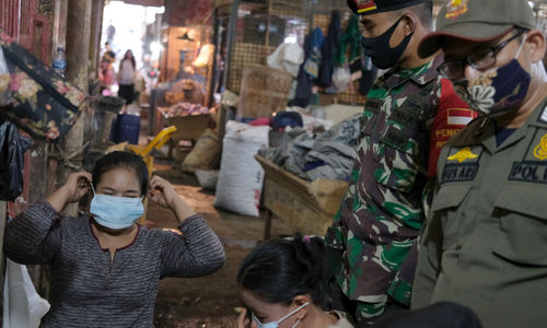 <p>Petugas gabungan TNI, Polri, dan Satpol PP melakukan peninjauan lapangan untuk penerapan protokol kesehatan para pedagang di Pasar Induk Kramat Jati, Jakarta Timur, Rabu 3 Juni 2020. Peninjauan lapangan dilakukan oleh satuan tugas gugus penanganan COVID-19 untuk menghimbau pedagang dan warga yang beraktivitas di area pasar tetap memperhatikan protokol kesehatan dengan menggunakan masker dan menjaga jarak untuk memutus penyebaran virus corona, terutama di wilayah  yang termasuk dalam zona merah. Foto: Ismail Pohan/TrenAsia</p>
