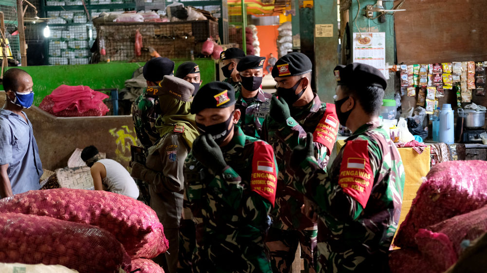 <p>Petugas gabungan TNI, Polri, dan Satpol PP melakukan peninjauan lapangan untuk penerapan protokol kesehatan para pedagang di Pasar Induk Kramat Jati, Jakarta Timur, Rabu 3 Juni 2020. Peninjauan lapangan dilakukan oleh satuan tugas gugus penanganan COVID-19 untuk menghimbau pedagang dan warga yang beraktivitas di area pasar tetap memperhatikan protokol kesehatan dengan menggunakan masker dan menjaga jarak untuk memutus penyebaran virus corona, terutama di wilayah  yang termasuk dalam zona merah. Foto: Ismail Pohan/TrenAsia</p>
