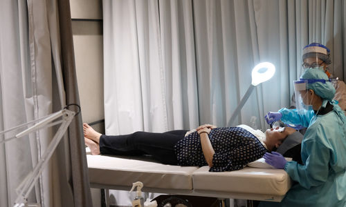 <p>Dokter Maria Fransisca Liu (kanan) bersama staf perawat melayani pelanggan di ruang treatment Klinik Kecantikan ERHA di Jakarta, Jum’at 19 Juni 2020. Memasuki tahapan New Normal klinik kecantikan ERHA menerapkan Clinic Safety Commitment, seperti mewajibkan seluruh staf dan dokter yang bertugas untuk melakukan pengecekan suhu dan menggunakan APD selama melayani pelanggan. Pihak klinik juga melakukan penyemprotan disinfektan dan melakukan pembersihan setiap 30 menit di kontak titik umum guna menghindari adanya virus. Pengunjung yang datang diwajibkan mengenakan masker, pengecekan suhu tubuh, mencuci tangan dengan sabun yang sudah disediakan, dan selalu menjaga jarak fisik dengan pengunjung lainnya di dalam klinik. Jumlah pengunjung waktu treatment juga dibatasi setiap harinya. Foto: Ismail Pohan/TrenAsia</p>
