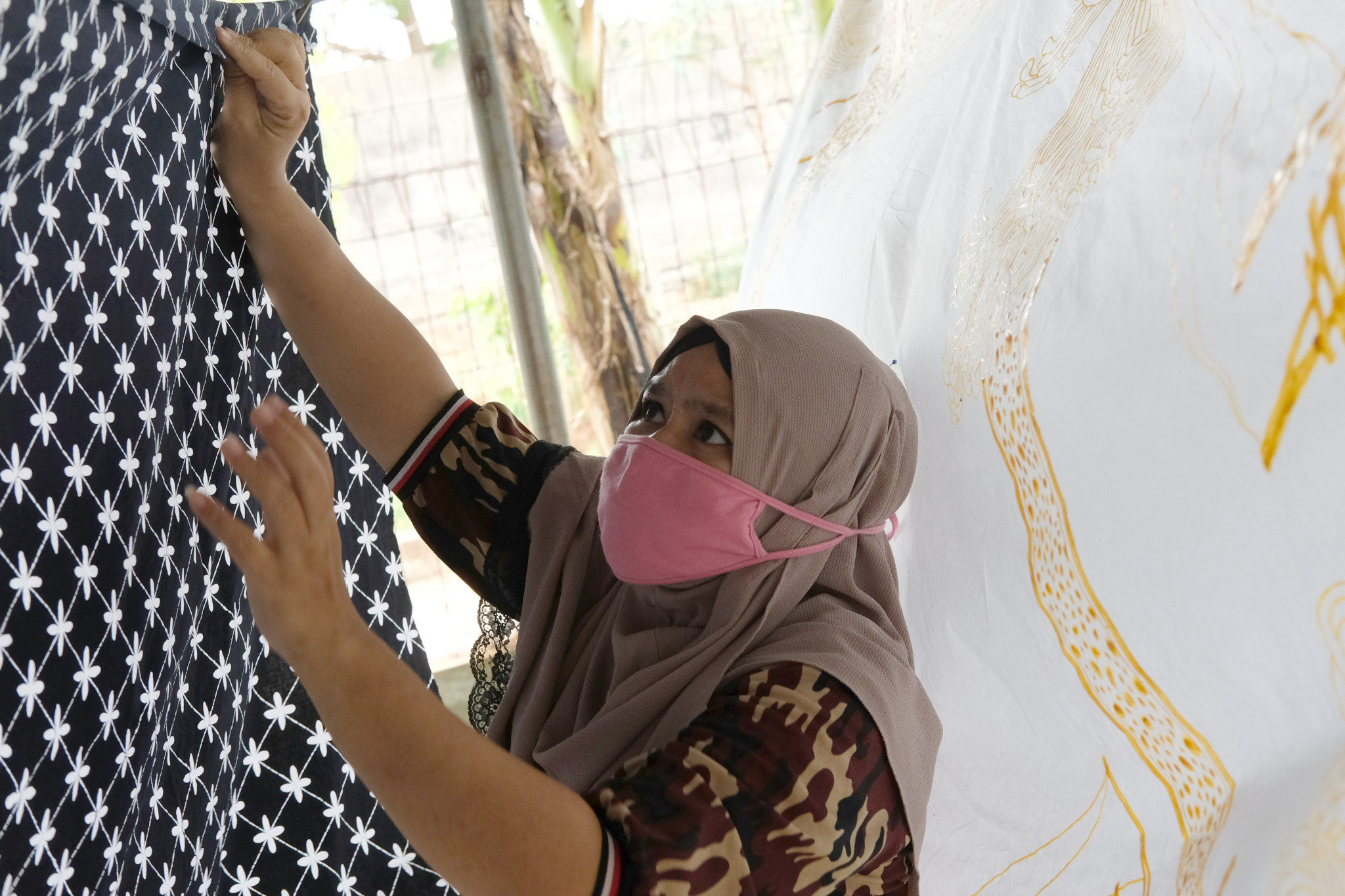 <p>Perajin menjemur batik di workshop Batik Marunda, di Rusun Marunda, Jakarta Utara, Selasa, 14 Juli 2020. Foto: Ismail Pohan/TrenAsia</p>
