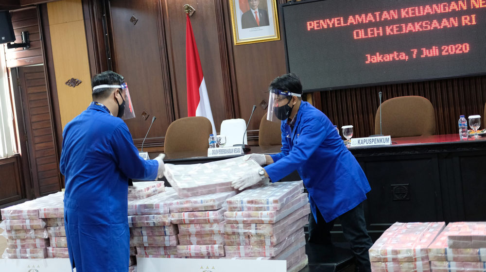 <p>Petugas merapikan barang bukti berupa uang sitaan di kantor Kejagung, Jakarta, Selasa, 7 Juli 2020. Kejagung mengeksekusi kilang LPG PT TLI di Tuban Jawa Timur dan uang senilai Rp 97 miliar hasil korupsi terpidana penjualan kondensat di BP Migas Honggo Wendratno. Foto: Ismail Pohan/TrenAsia</p>
