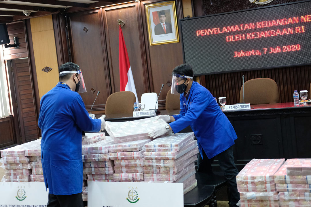 <p>Petugas merapikan barang bukti berupa uang sitaan di kantor Kejagung, Jakarta, Selasa, 7 Juli 2020. Kejagung mengeksekusi kilang LPG PT TLI di Tuban Jawa Timur dan uang senilai Rp 97 miliar hasil korupsi terpidana penjualan kondensat di BP Migas Honggo Wendratno. Foto: Ismail Pohan/TrenAsia</p>
