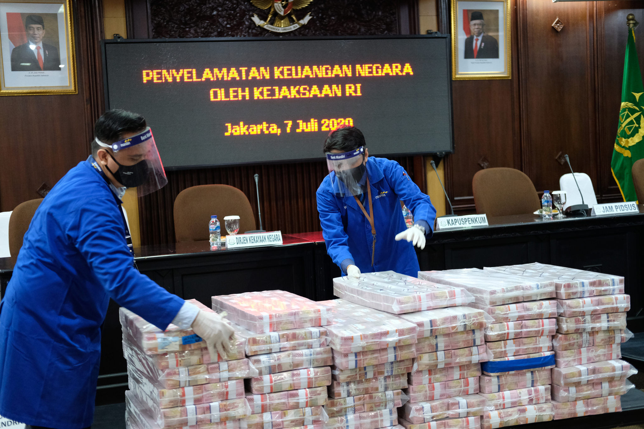 <p>Petugas merapikan barang bukti berupa uang sitaan di kantor Kejagung, Jakarta, Selasa, 7 Juli 2020. Kejagung mengeksekusi kilang LPG PT TLI di Tuban Jawa Timur dan uang senilai Rp 97 miliar hasil korupsi terpidana penjualan kondensat di BP Migas Honggo Wendratno. Foto: Ismail Pohan/TrenAsia</p>
