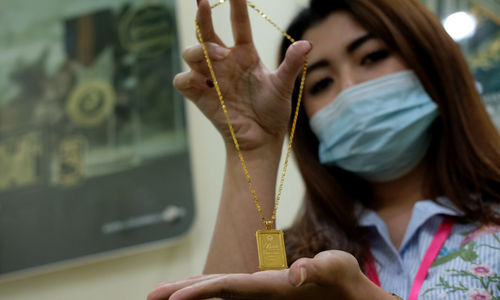 <p>Karyawan menunjukkan logam mulia di Butik Emas Antam, Jakarta, Kamis, 23 Juli 2020. Foto: Ismail Pohan/TrenAsia</p>

