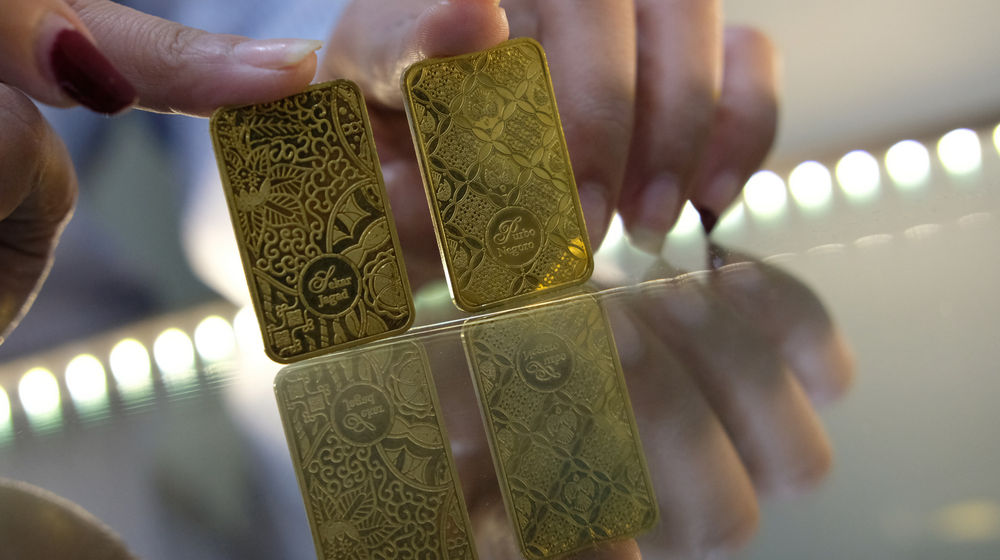 <p>Karyawan menunjukkan logam mulia di Butik Emas Antam, Jakarta, Kamis, 23 Juli 2020. Harga emas batangan PT Aneka Tambang Tbk. (Antam) pada hari ini, Kamis 23 Juli 2020 dipatok lebih rendah untuk ukuran 1 gram dibanderol Rp977.000, sedangkan pada posisi kemarin, Rabu 22 Juli 2020 sempat menyentuh level baru Rp982.000 untuk ukuran 1 gram, yang merupakan level tertinggi sepanjang sejarah.  PT Aneka Tambang Tbk. melansir penjualan emas di tingkat ritel tetap menggeliat kendati harga emas menyentuh rekor baru. Penjualan secara daring atau online diakui meningkat signifikan dalam tiga bulan terakhir. Foto: Ismail Pohan/TrenAsia</p>
