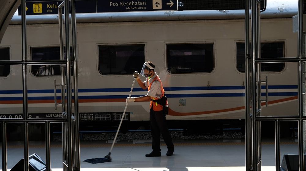 <p>Pekerja membersihkan area peron di dekat rangkaian kereta api jarak jauh KA Serayu relasi Pasar Senen- Purwokerto saat diberangkatkan dari Stasiun Pasar Senen, Jakarta, Jum’at 12 Juni 2020. PT Kereta Api Indonesia (Persero) kembali mengoperasikan kereta api (KA) jarak jauh dan KA lokal reguler secara bertahap mulai hari ini. pengoperasian kembali KA Reguler ini akan tetap diikuti dengan protokol pencegahan penyebaran Covid-19 yang diterapkan pada Masa Adaptasi Kebiasaan Baru. Foto: Ismail Pohan/TrenAsia</p>
