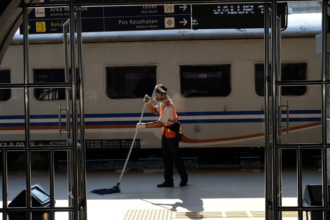 <p>Pekerja membersihkan area peron di dekat rangkaian kereta api jarak jauh KA Serayu relasi Pasar Senen- Purwokerto saat diberangkatkan dari Stasiun Pasar Senen, Jakarta, Jum&#8217;at 12 Juni 2020. PT Kereta Api Indonesia (Persero) kembali mengoperasikan kereta api (KA) jarak jauh dan KA lokal reguler secara bertahap mulai hari ini. pengoperasian kembali KA Reguler ini akan tetap diikuti dengan protokol pencegahan penyebaran Covid-19 yang diterapkan pada Masa Adaptasi Kebiasaan Baru. Foto: Ismail Pohan/TrenAsia</p>
